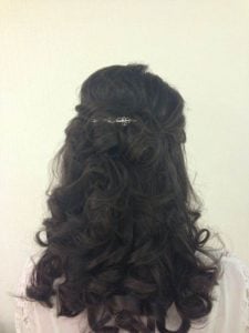 Back view of styled hair featuring defined curls and a decorative hair accessory.