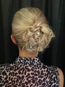 Blonde hair styled in an elegant updo with curls and decorative hairpins.