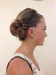 Side view of an elegant updo hairstyle with braids and twists on a model.