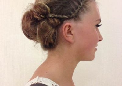 Side view of an elegant updo hairstyle with braids and twists on a model.
